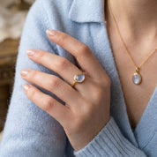 Dainty moonstone stacking ring and matching necklace shown on the model.