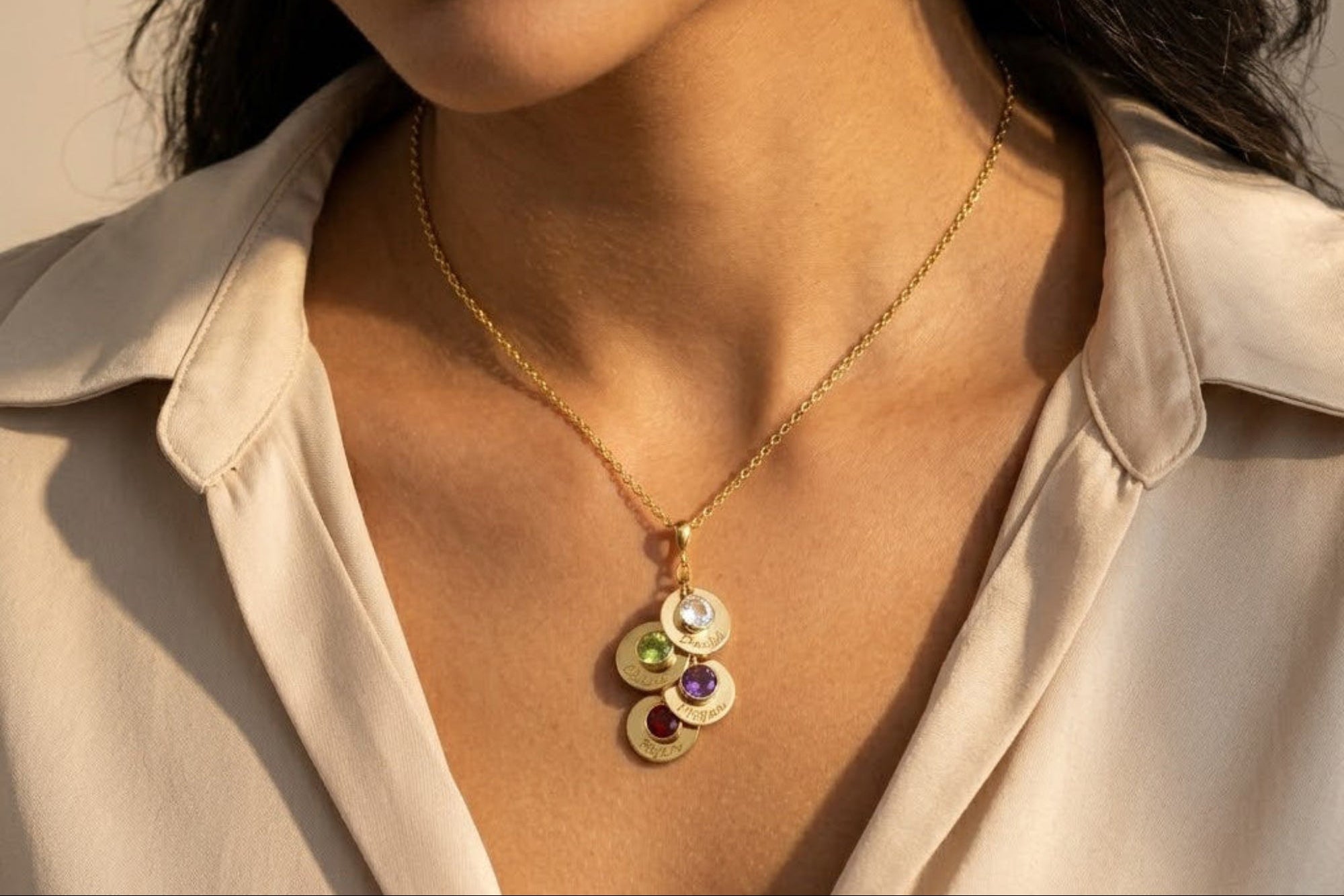 Model presenting a personalized family necklace featuring multiple engraved discs and birthstones—symbolic of children or grandchildren. A cherished gift idea for moms, grandmothers, or mothers-in-law to celebrate growing families.