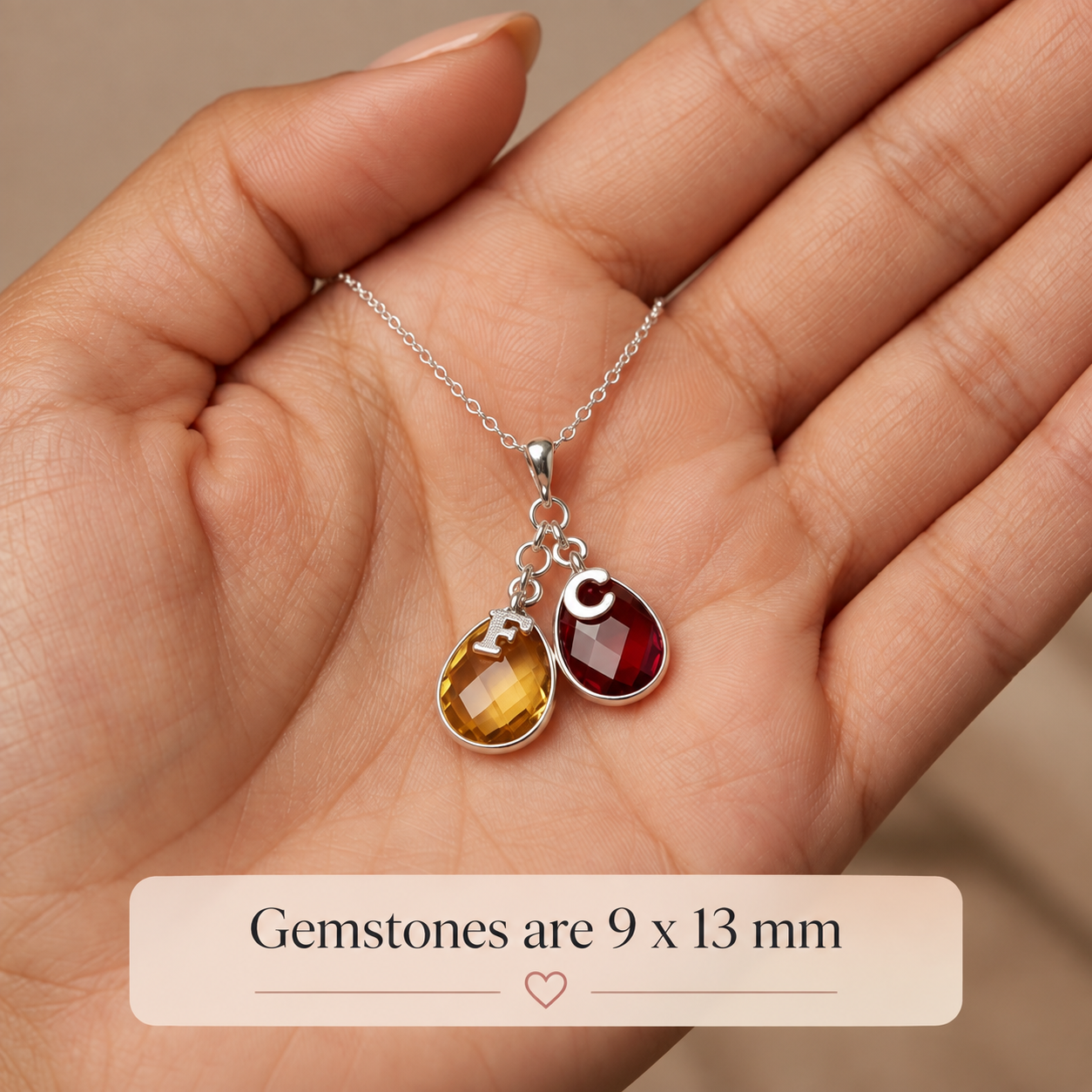 Close up of teardrop birthstones and letter charms 