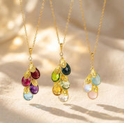 Family birthstone necklaces shown in gold and silver with colorful teardrop stones and initial charms, a meaningful custom necklace for mom or grandma.
