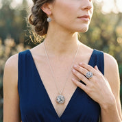 Woman wearing Constellation Orb statement necklace and matching cocktail ring with navy dress

