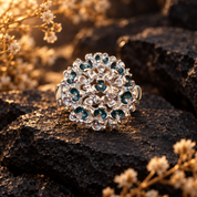 Custom Color Constellation Orb adjustable statement ring with silver openwork design and teal sparkling accents on dark stone

