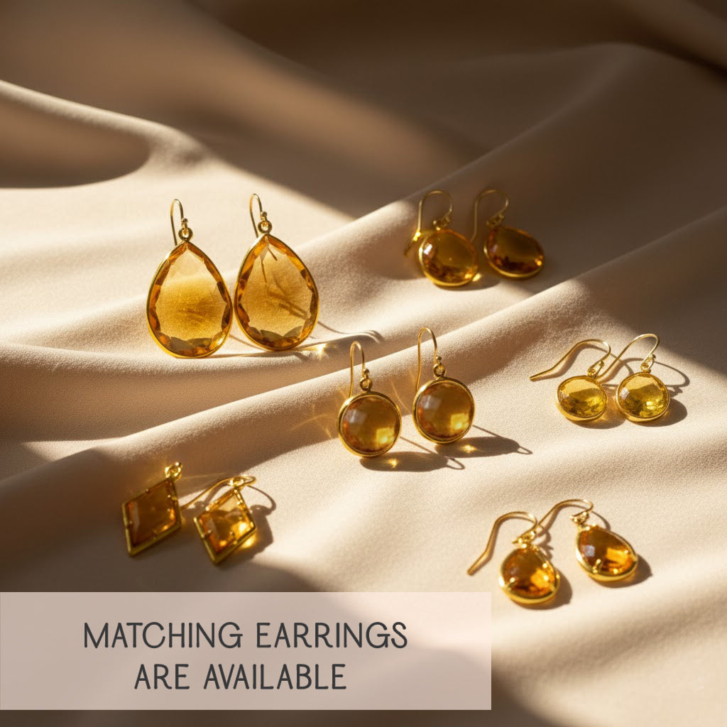 Matching citrine earrings and necklace set displayed on satin fabric, November birthstone gift set, faceted golden-yellow gemstone drop, gold vermeil and sterling silver metal options.