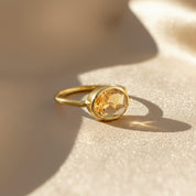 Oval-cut citrine ring in 18K gold vermeil, faceted yellow-orange gemstone set in a sleek bezel, handcrafted November birthstone ring symbolizing warmth and joy, timeless gold statement jewelry for her.