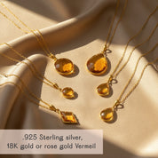 Citrine teardrop pendant necklaces styled on satin background with gold vermeil and sterling silver finishes, personalized November birthstone jewelry, minimalist gemstone necklace layering.