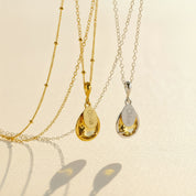 Citrine November birthstone necklaces shown in both .925 sterling silver and 14k gold-filled, each featuring a prong-set teardrop citrine gem paired with a small oval name tag engraved in script, hanging from delicate satellite chains on a soft neutral background. Personalized citrine pendants make meaningful November birthday gifts for mom, grandma, daughter or best friend, a warm golden keepsake she can wear every day, layered or alone for a minimalist look.