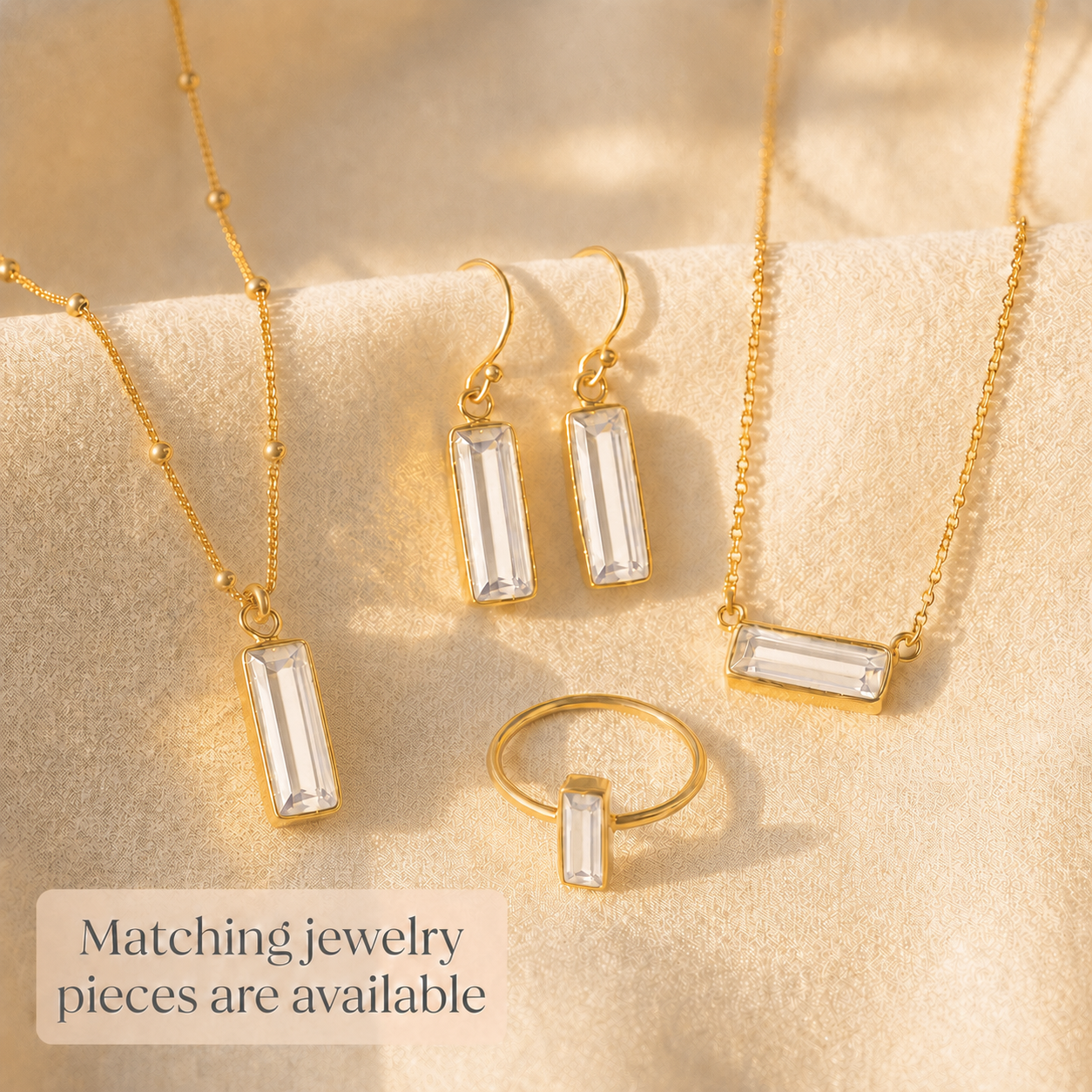 Matching Adira clear quartz jewelry pieces including earrings, necklaces, and ring in yellow gold vermeil.