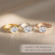 Oval clear quartz ring with gold and silver gemstone rings on satin background, mix and match birthstone ring collection