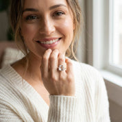 Woman wearing cushion cut clear quartz gold ring, 9mm square transparent gemstone in modern bezel setting, April birthstone jewelry styled in natural light, minimalist diamond alternative ring, elegant gold stacking birthstone ring, handcrafted fine jewelry for women, square bezel set white quartz statement ring gift