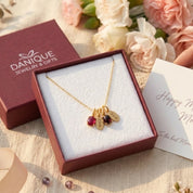 Personalized birthstone and name charm necklace displayed in Danique Jewelry signature gift-ready packaging.

