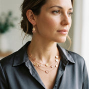 Woman wearing Blush Pink and Rose Gold double disc earrings with layered necklace


