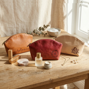 A personalized leather makeup bag with custom initials engraved on the front, designed as a stylish cosmetic pouch for storing everyday beauty essentials, travel toiletries, makeup brushes, and skincare products while adding a unique and thoughtful personalized touch.