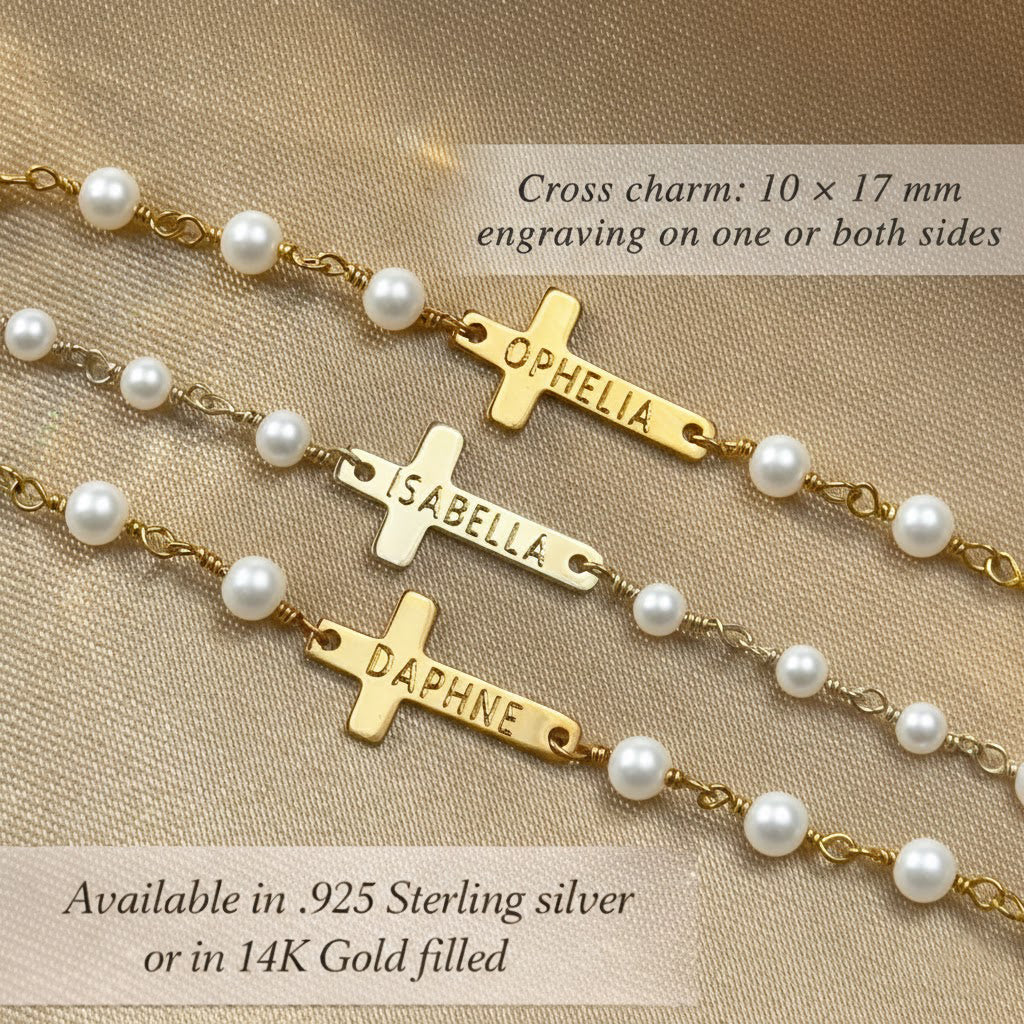 Personalized cross charm bracelet with engraved name, shown with pearl rosary-style chain on soft beige fabric background. Custom religious jewelry featuring horizontal cross charms engraved with names Ophelia, Isabella, and Daphne, available in 925 sterling silver or 14k gold filled. Minimalist Christian bracelet gift for baptism, communion, confirmation, flower girl, goddaughter, or child, with engraving on one or both sides and delicate handcrafted details.