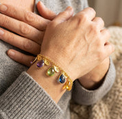 Personalized birthstone and initial charm bracelet worn on wrist, meaningful custom bracelet gift for mom