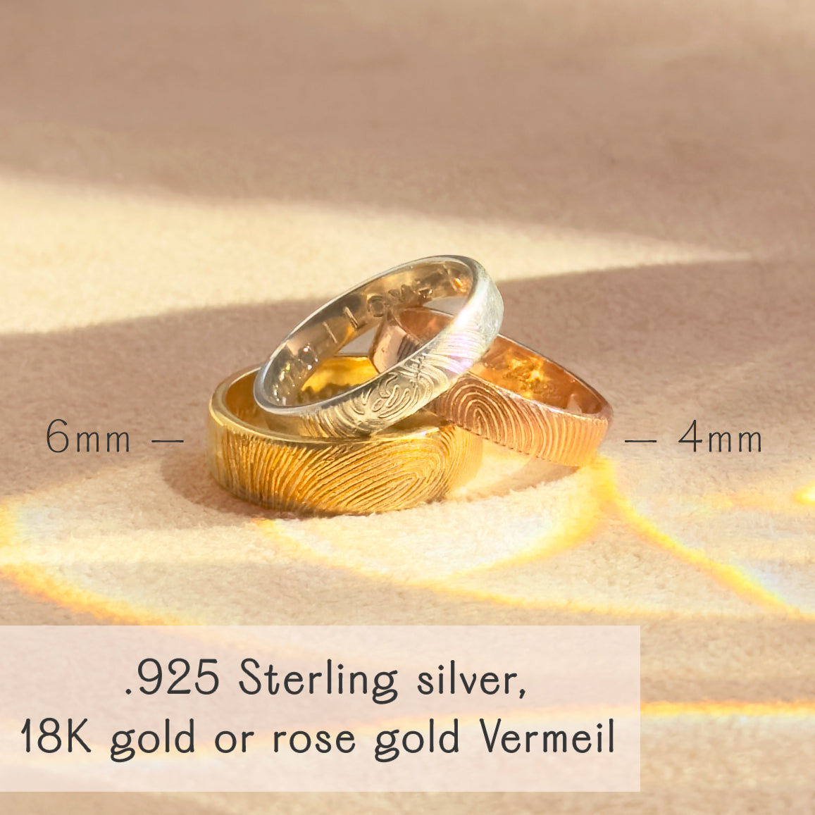 Stack of custom fingerprint rings in sterling silver, yellow gold vermeil, and rose gold vermeil resting on sunlit fabric. Bands feature a deeply etched fingerprint pattern with widths shown 6 mm and 4 mm. Personalized wedding or anniversary bands for him or her, comfort-fit, hypoallergenic .925 silver or 18K gold vermeil with optional inside engraving. Crafted from your photo for a meaningful memorial keepsake; durable everyday finish, polished or satin. Handmade by Danique Jewelry in Massachusetts.