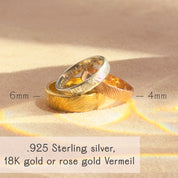 Stack of custom fingerprint rings in sterling silver, yellow gold vermeil, and rose gold vermeil resting on sunlit fabric. Bands feature a deeply etched fingerprint pattern with widths shown 6 mm and 4 mm. Personalized wedding or anniversary bands for him or her, comfort-fit, hypoallergenic .925 silver or 18K gold vermeil with optional inside engraving. Crafted from your photo for a meaningful memorial keepsake; durable everyday finish, polished or satin. Handmade by Danique Jewelry in Massachusetts.