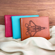 Custom engraved leather wallets in bright colors, including turquoise and raspberry, shown with rocket engraving design. Personalized leather wallet can be engraved with handwriting, initials, monogram, or coordinates for a meaningful gift. A stylish engraved wallet for men or boys, ideal personalized gift for Father’s Day, Christmas, or birthdays. Handcrafted wallet gift for husband, dad, or boyfriend.