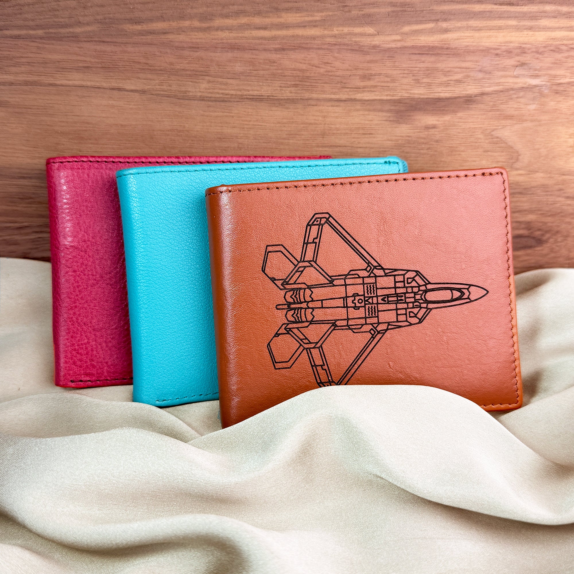 Custom engraved leather wallets in bright colors, including turquoise and raspberry, shown with rocket engraving design. Personalized leather wallet can be engraved with handwriting, initials, monogram, or coordinates for a meaningful gift. A stylish engraved wallet for men or boys, ideal personalized gift for Father’s Day, Christmas, or birthdays. Handcrafted wallet gift for husband, dad, or boyfriend.