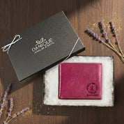 Custom engraved leather wallet in deep berry color displayed inside a Danique Jewelry & Gifts gift box with soft padding, featuring a personalized monogram and wreath design; premium handcrafted wallet ideal for birthdays, anniversaries, Father’s Day and meaningful personalized gifting.