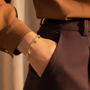 Custom birthstone dangle bracelet worn on wrist, dainty gold family bracelet with multiple birthstones representing children or grandchildren, meaningful gift for mom or grandma, Valentine’s Day jewelry idea