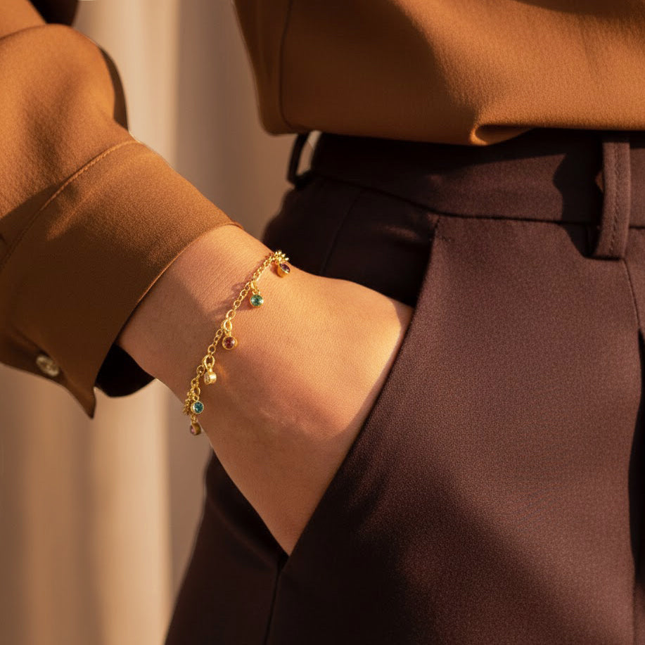 Custom birthstone dangle bracelet worn on wrist, dainty gold family bracelet with multiple birthstones representing children or grandchildren, meaningful gift for mom or grandma, Valentine’s Day jewelry idea