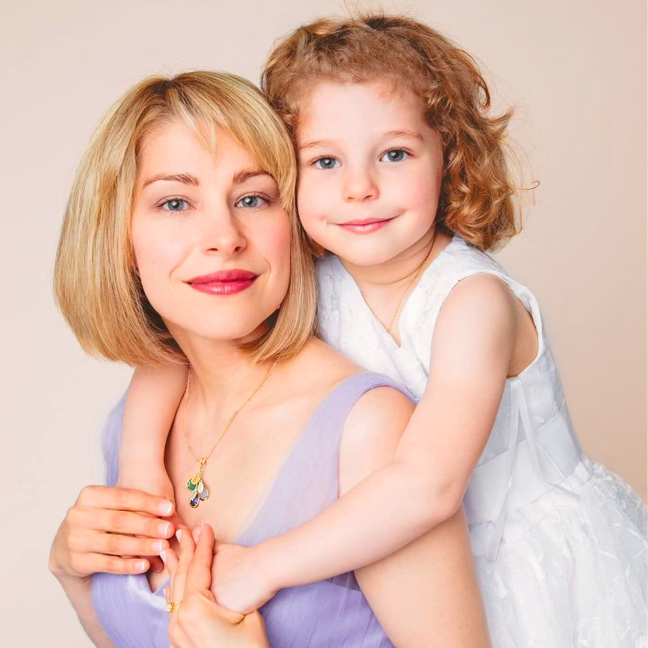 Mother wearing an 18k vermeil gold customized teardrop birthstone pendant necklace while sitting with her daughter cascade necklace