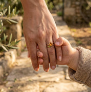 Mother wearing a custom birthstone ring set while holding a child’s hand, a meaningful jewelry gift for moms and grandmothers.
