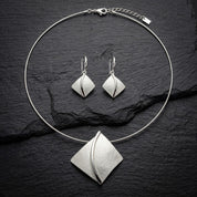 Soft Pearl sculpted leaf necklace and matching drop earrings displayed on black background
