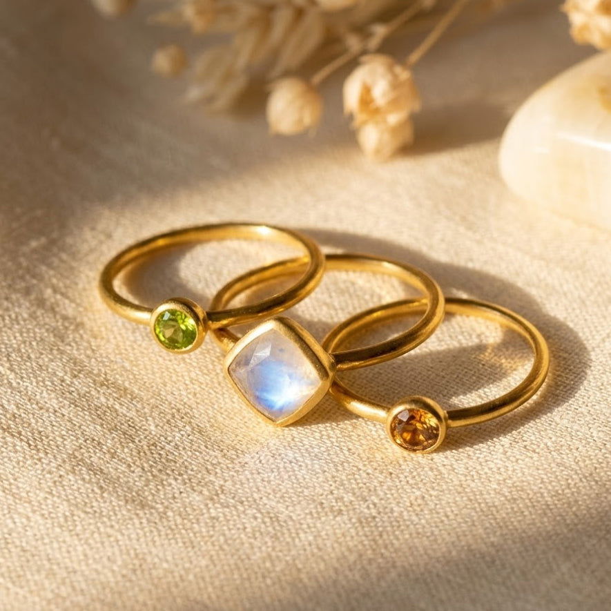 three diamond shape  birthstone rings in gold with moonstone and citrine-style gemstones, shown as a custom family ring stack for mom.