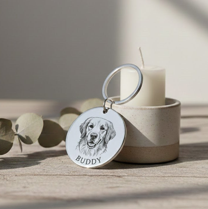Close-up of custom engraved dog portrait keychain featuring detailed illustration and pet name. Personalized stainless steel pet keychain created from customer photo. Meaningful pet keepsake designed for dog lovers, memorial gifts, or everyday reminders of a beloved pet.