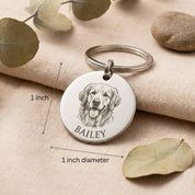 Personalized pet portrait keychain shown with size reference, featuring a round engraved disc with detailed dog illustration and pet name. Custom pet keychain created from customer photo, crafted in stainless steel. Ideal size for everyday use as a pet memorial keychain, dog lover gift, or personalized keepsake.