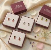 Gift-ready custom birthstone stud earrings displayed in Danique Jewelry boxes, personalized with one, two, or three birthstones in sterling silver or gold.