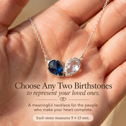 Hand holding a custom two birthstone necklace with two 9 x 13 mm faceted teardrop gemstones.