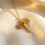 Gold dragonfly pendant necklace flat lay on warm neutral fabric, closeup of custom birthstone center and wing stones, delicate chain and nature inspired jewelry style, personalized birth month necklace in sterling silver or gold vermeil, perfect birthday gift, graduation gift, bridesmaid jewelry