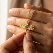 Hands holding gold dragonfly pendant necklace closeup, showing custom birthstone gemstone color choice and fine details, personalized dragonfly birthstone necklace in sterling silver or gold vermeil, meaningful gift for her, nature lover jewelry, sympathy memorial or remembrance necklace