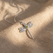 Silver dragonfly birthstone necklace flat lay with chain and pendant shadow, detailed wings with stones and center birthstone gem, personalized dragonfly pendant necklace in 925 sterling silver / gold vermeil / rose gold vermeil, dainty gift for mom, daughter, best friend