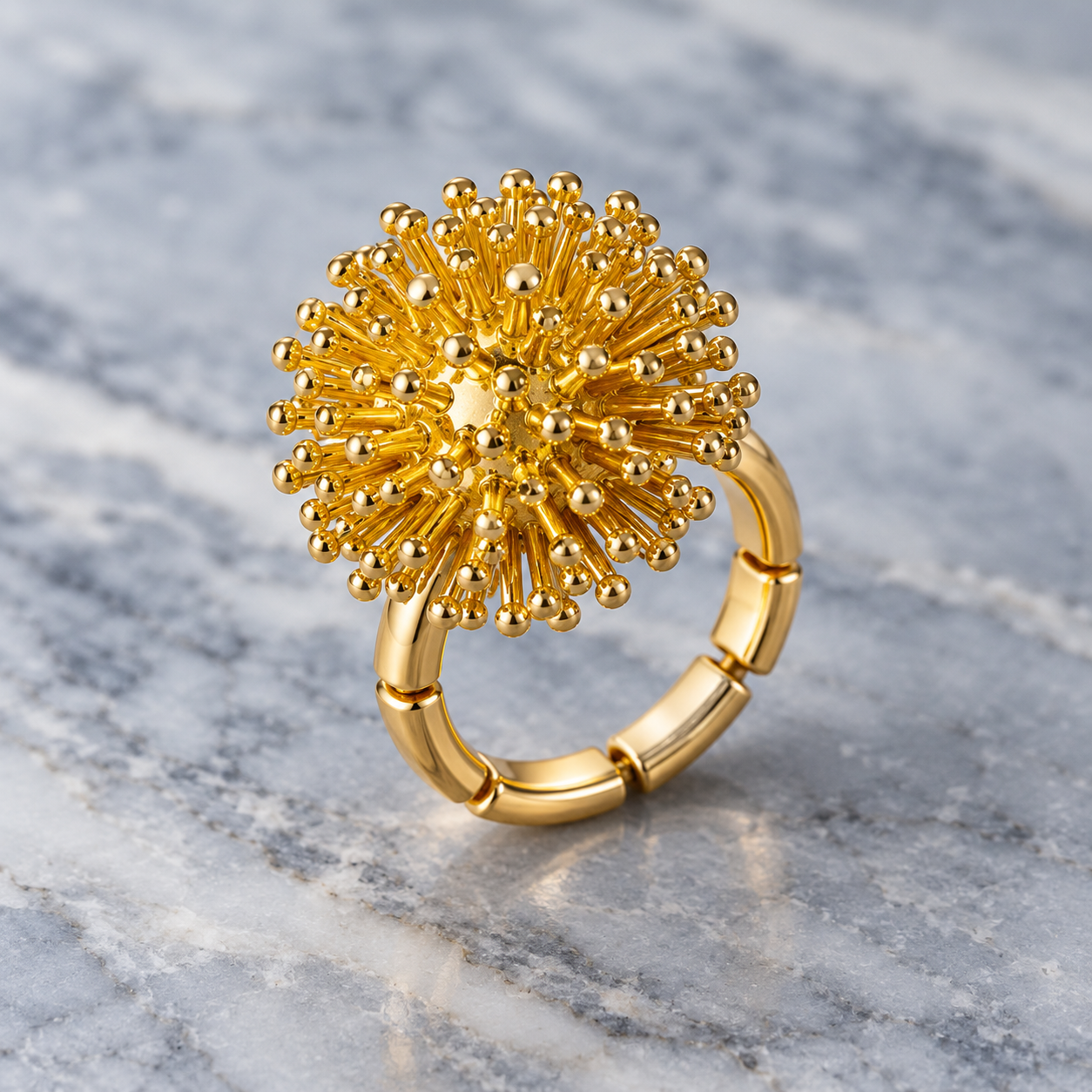 Gold Dandelion Puff sculptural floral ring displayed on gray stone

