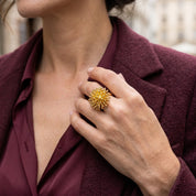 Woman wearing Gold Dandelion Puff statement ring with burgundy blazer

