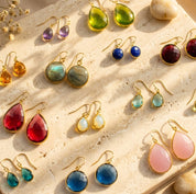 Colorful birthstone drop earrings in teardrop, round, and geometric gemstone styles.