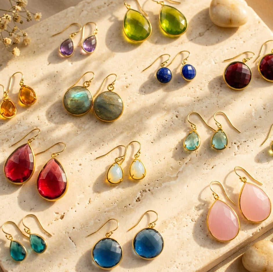 Colorful birthstone drop earrings in teardrop, round, and geometric gemstone styles.