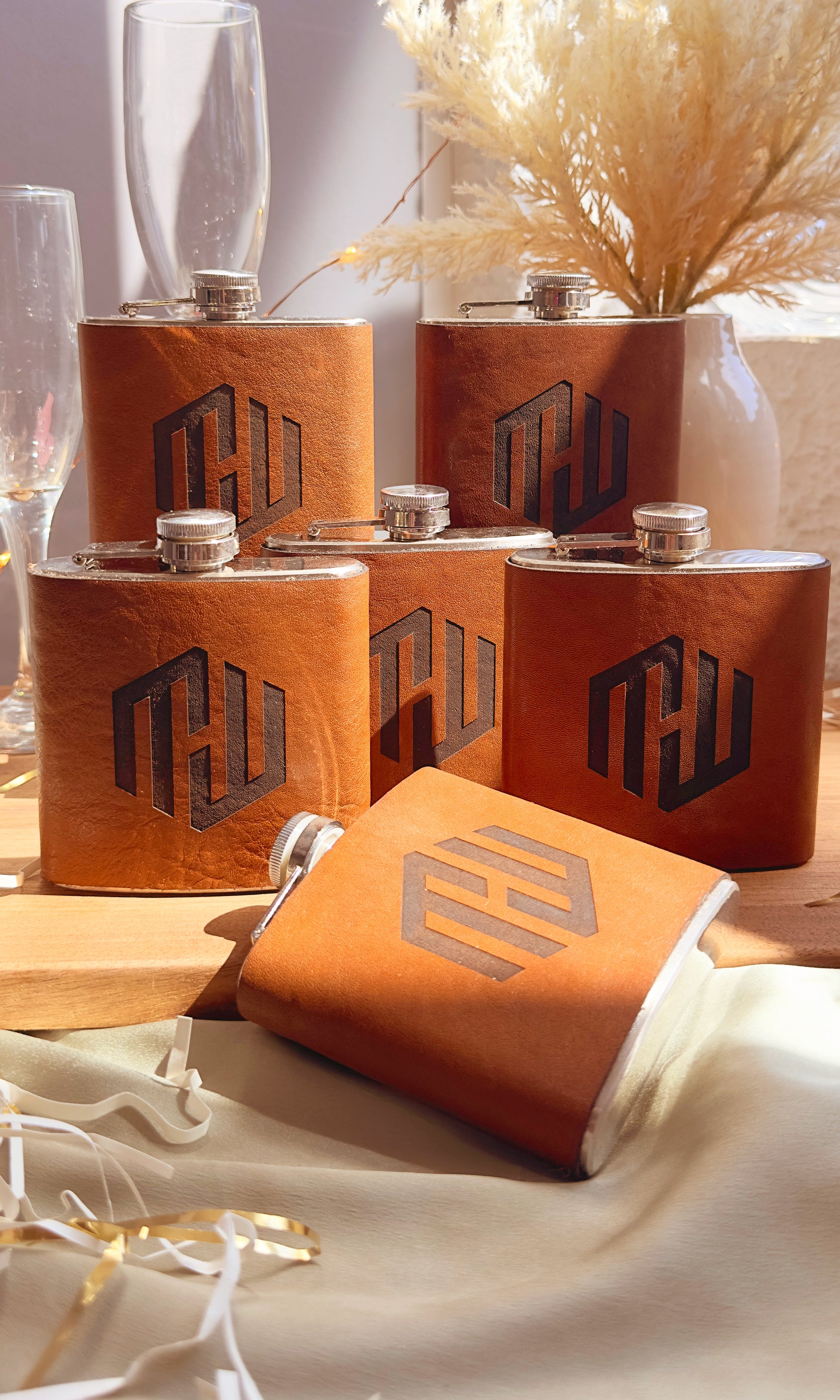 Personalized leather wrapped flasks with engraved initials, perfect party favors and corporate gifts. Custom groomsmen gifts for wedding parties, bachelor party accessories, or milestone birthday celebrations. Unique engraved drinkware for large gatherings, company events, or holiday parties. Stylish and reusable flask with durable stainless steel and custom leather wrap, engraved with monogram, logo, or name. Thoughtful bulk gift idea for group celebrations and special occasions.