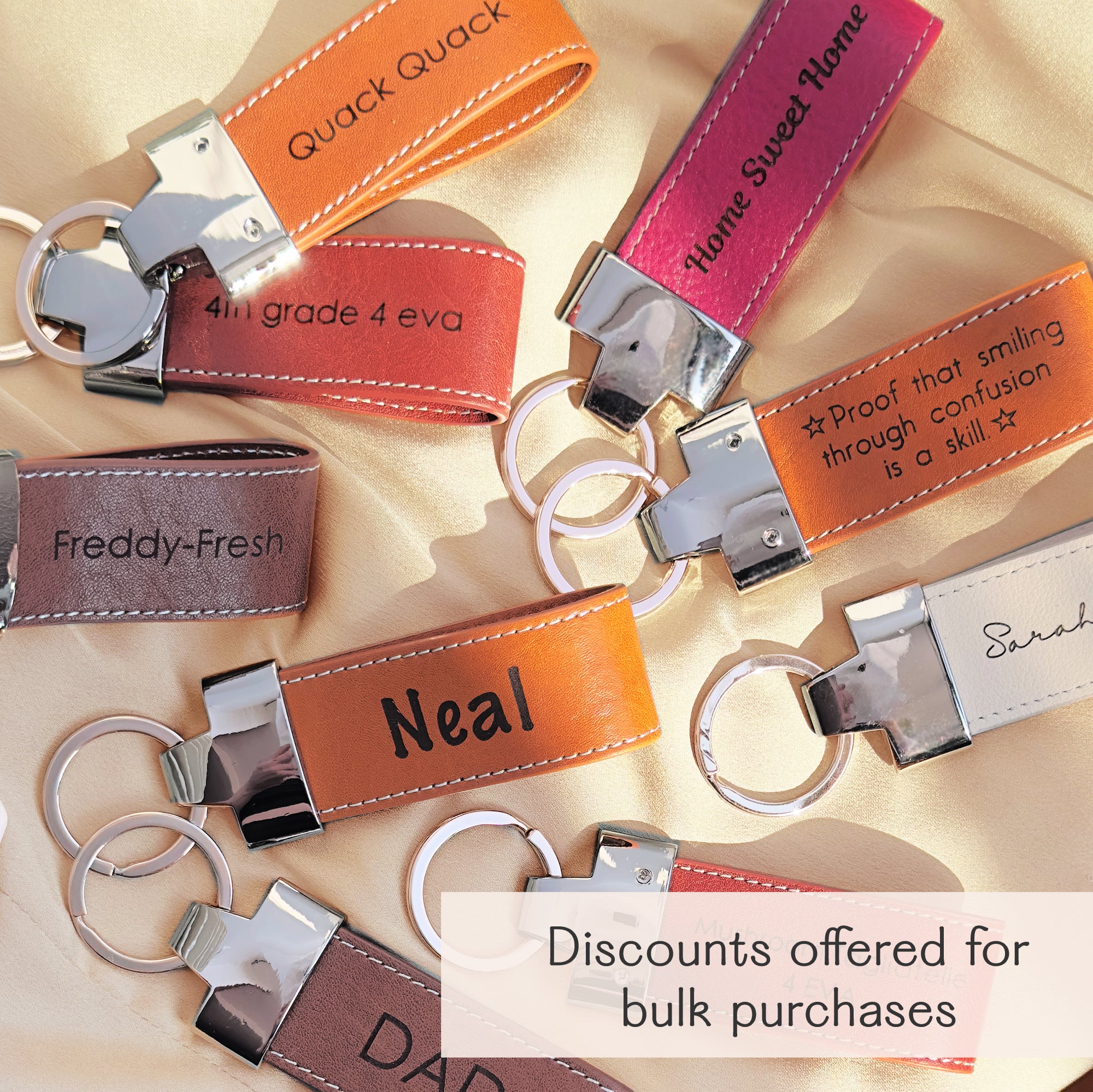 Colorful assortment of personalized large leather keychain loops, each custom engraved with names, quotes, or phrases like “Neal,” “Home Sweet Home,” and “Freddy-Fresh.” These durable keychains feature silver hardware and stitched detailing, ideal for teachers, dads, grads, coworkers, and bulk gifting. Perfect for custom promotional items, stocking stuffers, event favors, or employee appreciation gifts. Discounts available for group orders and personalized text options on each piece.