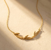 Personalized leaf necklace with engraved names on gold leaf charms, a meaningful custom family necklace for mom or grandma with children’s or grandchildren’s names.
