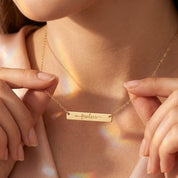Personalized engraved bar necklace in yellow gold filled worn on woman
Custom horizontal bar necklace engraved with meaningful word in yellow gold
