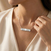 Woman wearing a personalized sterling silver fingerprint bar necklace, minimalist horizontal bar pendant engraved with a custom fingerprint, delicate everyday necklace styled on model, meaningful memorial and sentimental jewelry gift