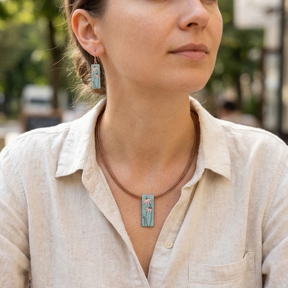 Woman wearing pink and blue floral dangle earrings
