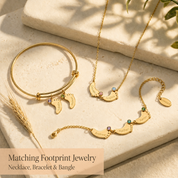 Matching footprint jewelry set with necklace, bracelet, and bangle, personalized with engraved charms and birthstones.