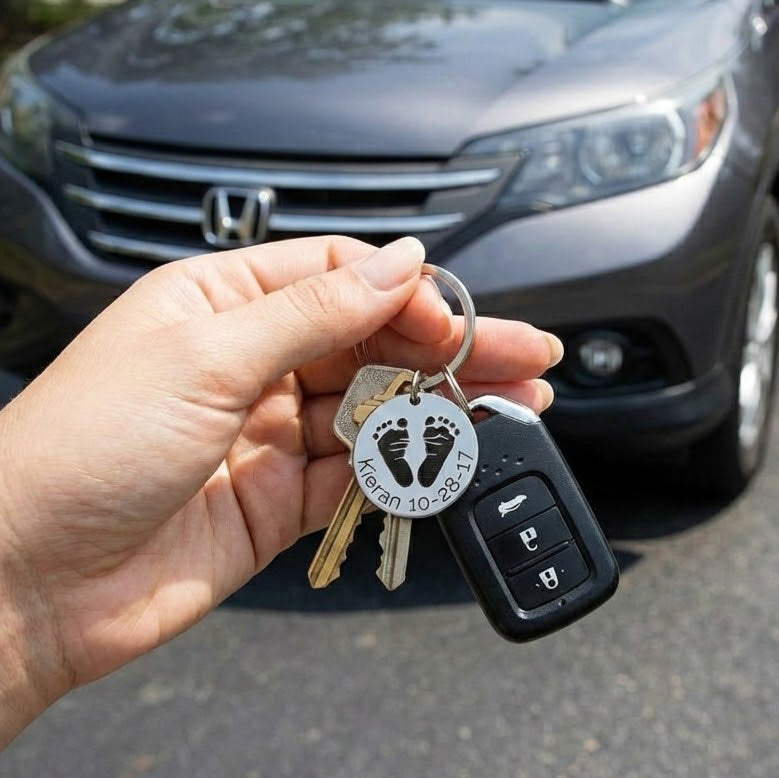 Personalized baby footprint keychain attached to car keys, showing everyday use of an engraved baby footprint keepsake made from stainless steel. This custom baby footprint keychain transforms a real baby footprint into wearable jewelry, making it a meaningful gift for new moms or grandmas who want a daily reminder of their child or grandchild.