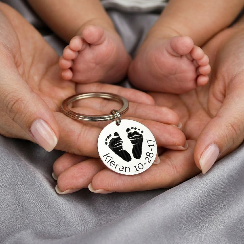 Actual baby footprint keychain personalized from a real newborn footprint, shown resting in a mother’s hands beneath tiny baby feet. This custom baby footprint keychain is engraved with the child’s name and birth date, creating a meaningful keepsake gift for a new mom or grandma. Made from durable stainless steel, this sentimental baby footprint jewelry preserves a baby’s first moments in a timeless, wearable memory.