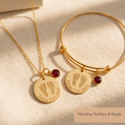 Matching footprint necklace and bangle bracelet set with engraved baby footprints, name, date, and birthstone charms.
